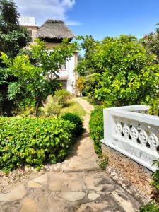 a garden with a stone path leading to a house at Makao Nafuu Aprtments Malindi in Malindi