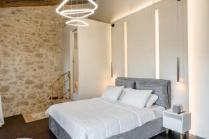 a bedroom with a bed and a stone wall at Athali Villa in Krousón