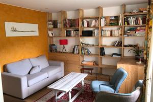 sala de estar con sofá, mesa y estanterías en At The Other End Of The World - Family Cottage For, en Cenves