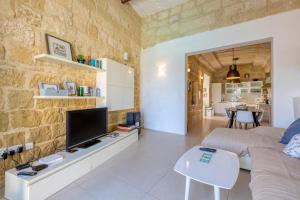 sala de estar con sofá y TV en Ta'Patee Pool Farmhouse in Gozo - Happy Rentals, en Il-Wilġa