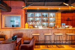 a bar in a restaurant with stools at The Fern Surya Resort Kasauli Hills, Dharampur in Kasauli