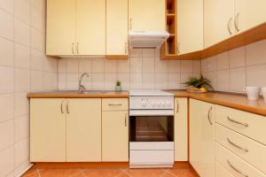 una cocina con armarios blancos y fregadero en Bright & Cozy Apartments in the City Center by Renters, en Varsovia
