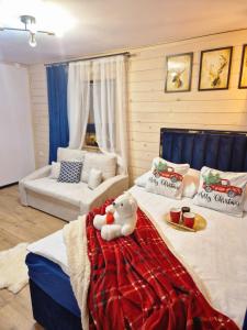 a bedroom with a bed with a teddy bear on it at Góralska Chata in Czarna Góra +90 photos