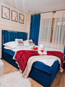 un osito de peluche sentado en una cama en un dormitorio en Góralska Chata en Czarna Góra