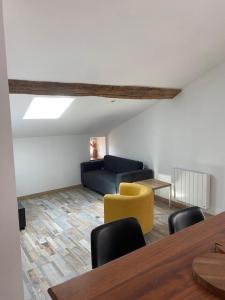 een woonkamer met een gele stoel en een bank bij Sainte Madeleine's Appartments For 4 in Tournus