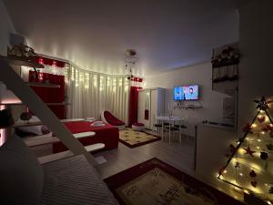 a living room with a christmas tree and a television at Raduga West 'Amber' Apartment in Koshkolʼ