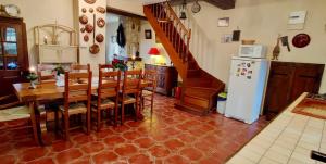 eine Küche und ein Esszimmer mit einem Tisch und einem Kühlschrank in der Unterkunft Charming Country House In The Heart Of Burgundy in Cormatin