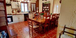 eine Küche mit einem Holztisch und Stühlen in der Unterkunft Charming Country House In The Heart Of Burgundy in Cormatin