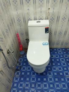 a white toilet in a bathroom with blue tiles at PEARL HUT home stay vythiri Wayanad in Vythiri