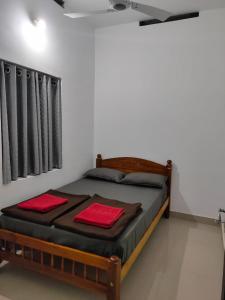 una camera da letto con un letto con asciugamani rossi di PEARL HUT home stay vythiri Wayanad a Vythiri