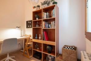 Habitación con escritorio y estante para libros. en Sunny Apt Barcelona 22@, en Barcelona