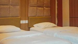 2 letti posti uno accanto all'altro in una stanza di Mahestu Hotel a Kuta