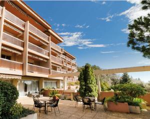 a building with chairs and tables in front of it at Résidence de Grasse in Grasse