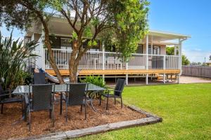 a table and chairs in front of a house at The Relax Shack - Pet Friendly - 8 Mins Walk to Beach in Culburra Beach