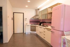 Il comprend une cuisine équipée d'un réfrigérateur rose et d'un évier. dans l'établissement The Heart of Ostia - free parking, à Lido di Ostia