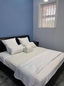 Un dormitorio con una cama con una caja. en Beverley Grove Guest House en Gqeberha