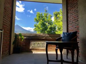 a table and chair in front of a window with a view at Umah De Madya & Rooftop De Madya in Munduk