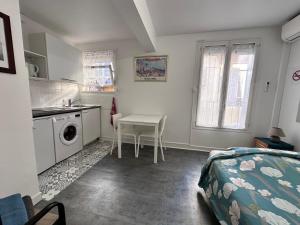 ニースにあるBottéro, climatisé, parking possibleのベッドルーム1室(テーブル付)、キッチン(洗濯機付)