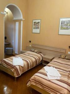 twee bedden in een kamer met een boog bij Hotel Pavo in Tbilisi City