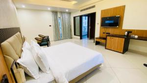 a hotel room with a bed and a television at 7 Hills Hotel & Resort in Nalanda