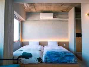 two beds in a small room with a window at KAGANHOTEL - Vacation STAY 16986v in Kyoto