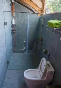 a bathroom with a toilet and a glass shower at Bavi Hideaway Retreat - Venuestay in Ba Vì