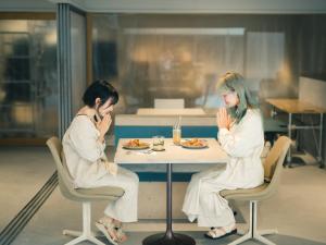 KAGANHOTEL - Vacation STAY 20650v في كيوتو: كانتا جالستين على طاولة لتناول الطعام
