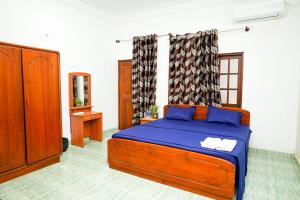 a bedroom with a bed with blue sheets and a mirror at The Anam Hotel - Wellawatte in Colombo
