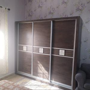 Habitación con armario con estanterías de madera. en العين الهيلي مصباح بيت 10, en Al Ain
