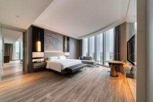 a hotel room with a bed and a television at Courtyard by Marriott Hangzhou Xihu in Hangzhou