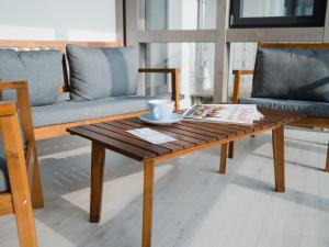 a coffee table with a cup and a newspaper on it at Gästehaus Frieda in Schweigen-Rechtenbach