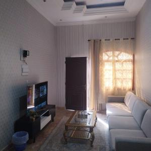 sala de estar con sofá y TV en العين الهيلي مصباح بيت 10, en Al Ain