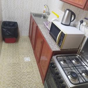 encimera de cocina con microondas y fregadero en العين الهيلي مصباح بيت 10, en Al Ain