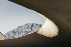 a view of a snow covered mountain from a building at Hotel Maistra 160 in Pontresina