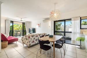 a living room with a table and a couch at Cape Apartments in Byron Bay