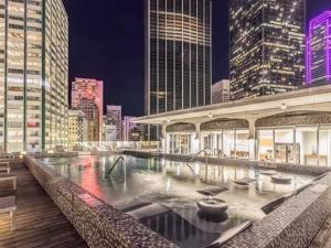 a large swimming pool in a city at night at On The Go Stays in Dallas