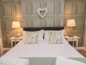 une chambre avec un lit avec un cœur sur le mur dans l'établissement Redshank, à Morpeth