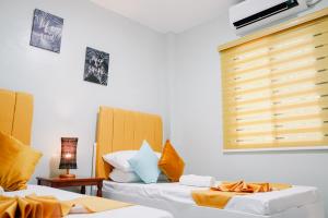a room with two beds and a window at Near Airport Transient Inn - 2 Bedroom Suite in Puerto Princesa City