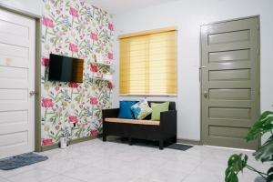 - un salon avec une télévision et un canapé dans l'établissement Near Airport Transient Inn 2-Bedroom Space -Richkizz 1, à Puerto Princesa