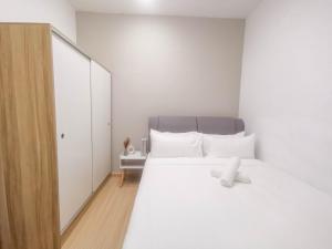 Un dormitorio blanco con una cama blanca con un osito de peluche. en D' Sara Sentral Suites by Manhattan Group, en Sungai Buloh