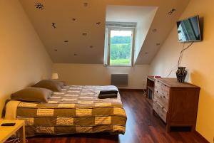 - une chambre avec un lit, une télévision et une fenêtre dans l'établissement Maison Maizeray Saint Martin du Tartre, à Saint-Martin-du-Tartre
