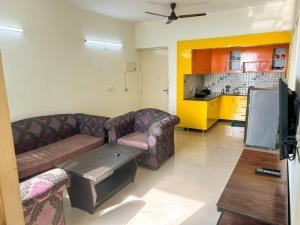 un soggiorno con 2 divani e un tavolo di Friend's Place a Greater Noida