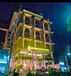 a tall building with a sign on it at night at Grand River View Hotel - Rajshahi in Rājshāhi