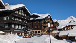 um alojamento de esqui com neve no telhado em Imhof Alpine B&B Apartments em Bettmeralp