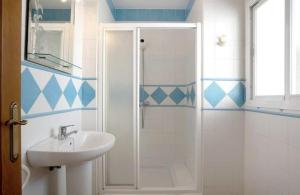 een witte badkamer met een wastafel en een douche bij Apartamento Pérez Zara 6 in Conil de la Frontera