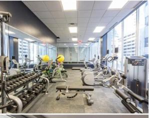 een fitnessruimte met rijen loopbanden en machines bij On The Go Stays in Dallas