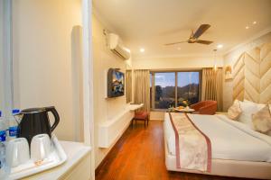 Habitación de hotel con cama y ventana en Amritara Surya, Mcleodganj, Dharamshala en Dharamshala