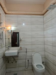 a bathroom with a toilet and a sink at Hotel Ozone 24 in Butwāl