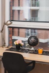 格但斯克的住宿－Studio Fahrenheit in Central Gdańsk by Renters，一张桌子,上面放着一碗鲜花和一盏灯