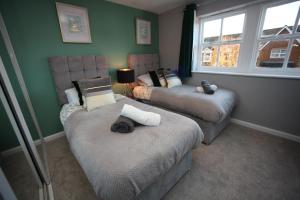 a room with two beds and a window at Oxford's Most Stylish House - Garden & Parking in Oxford